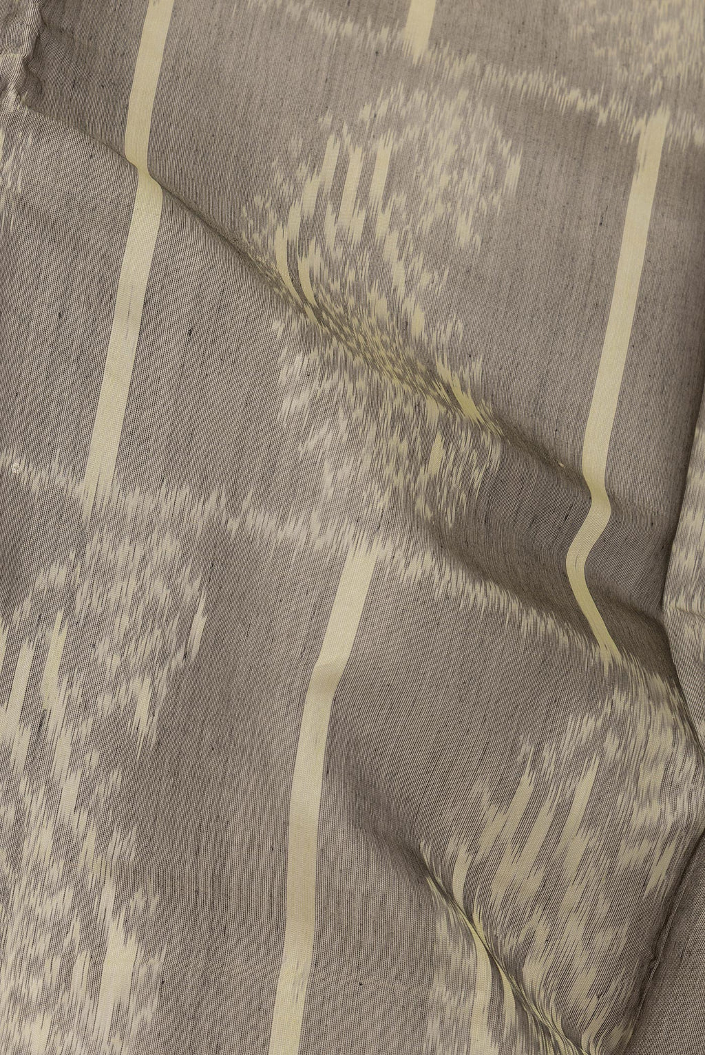 Close up of Grey Silk Cotton Saree with Ikat Print on the body and Zari Border.  displaying folds