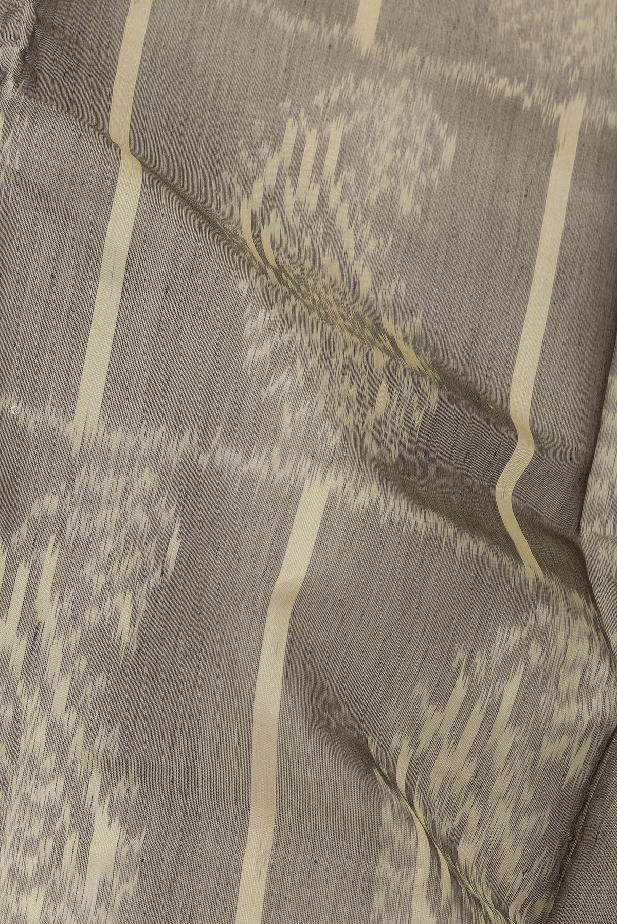 Close up of Grey Silk Cotton Saree with Ikat Print on the body and Zari Border.  displaying folds