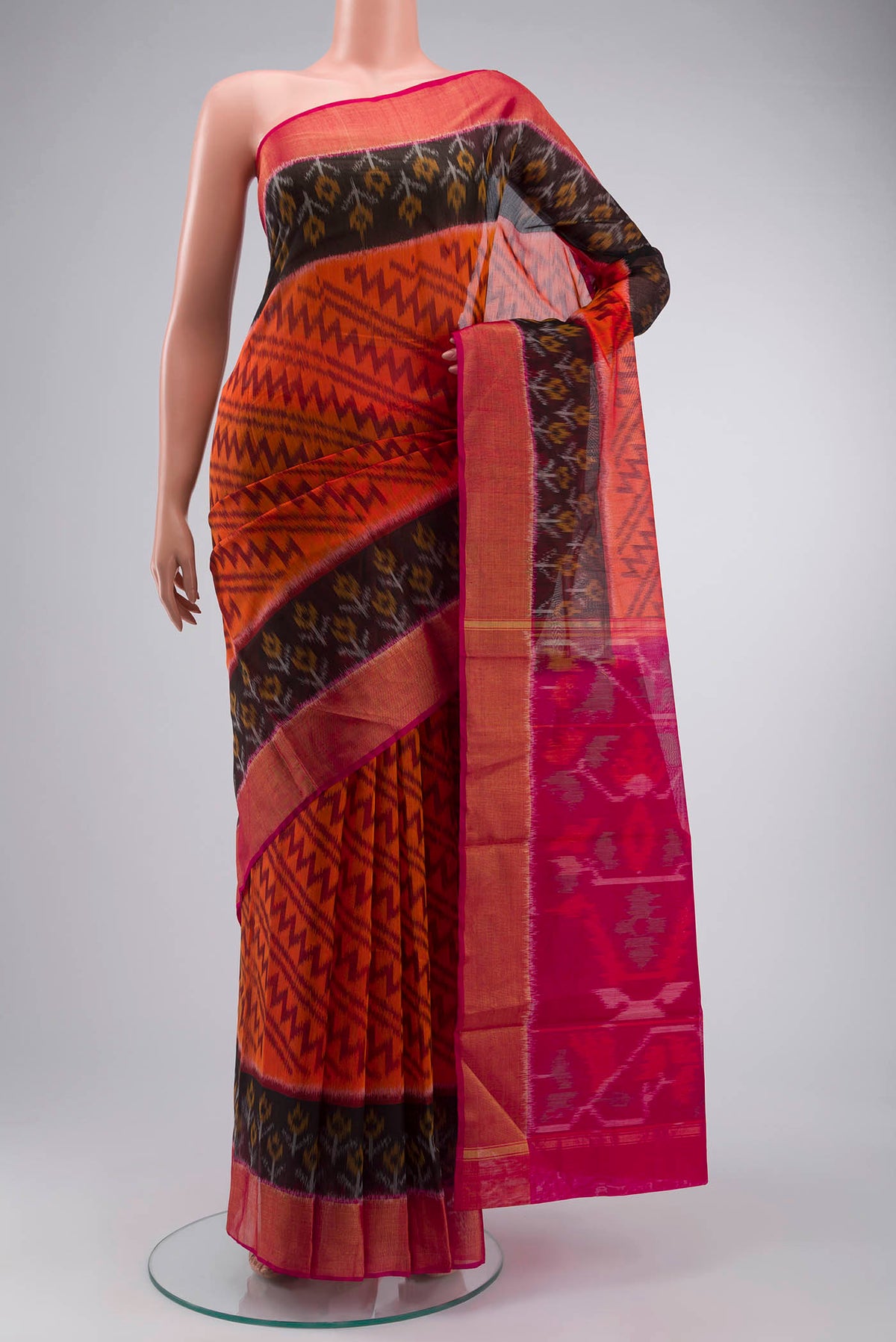 Orange Silk Cotton Saree with Ikat Print on the body and Zari Border displayed on a mannequin
