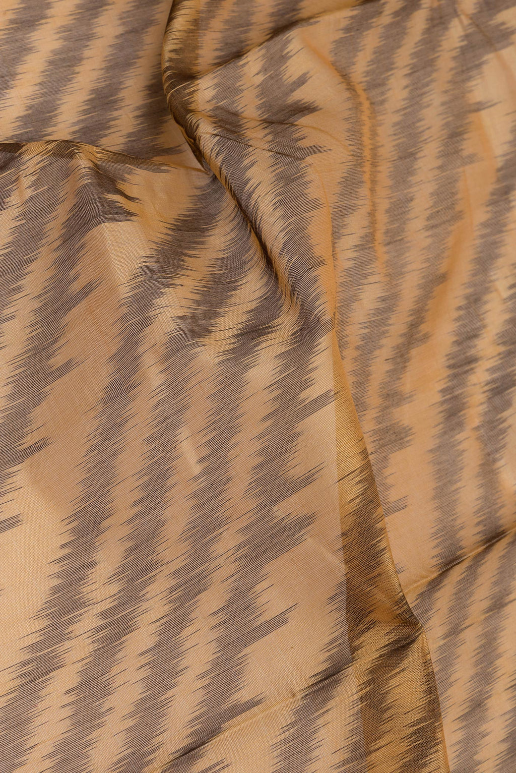 Close up of Brown Silk Cotton Saree with Ikat Print on the body and Ikat Border.  displaying folds