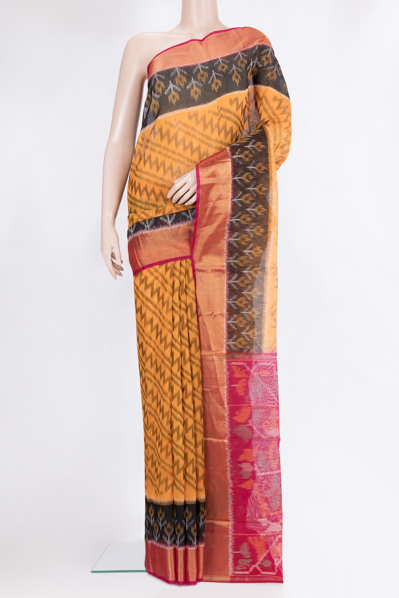 Orange Silk Cotton Saree with Ikat Print on the body and Zari Border.  displayed on a mannequin