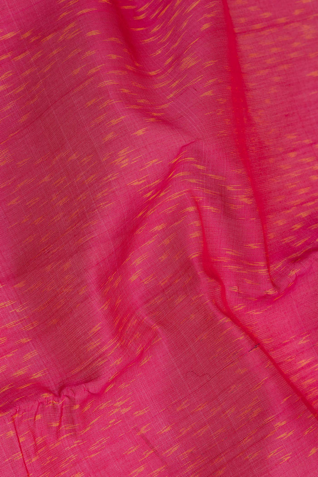 Close up of Dark Pink Silk Cotton Saree with Ikat Print on the body and Zari Border.  displaying folds
