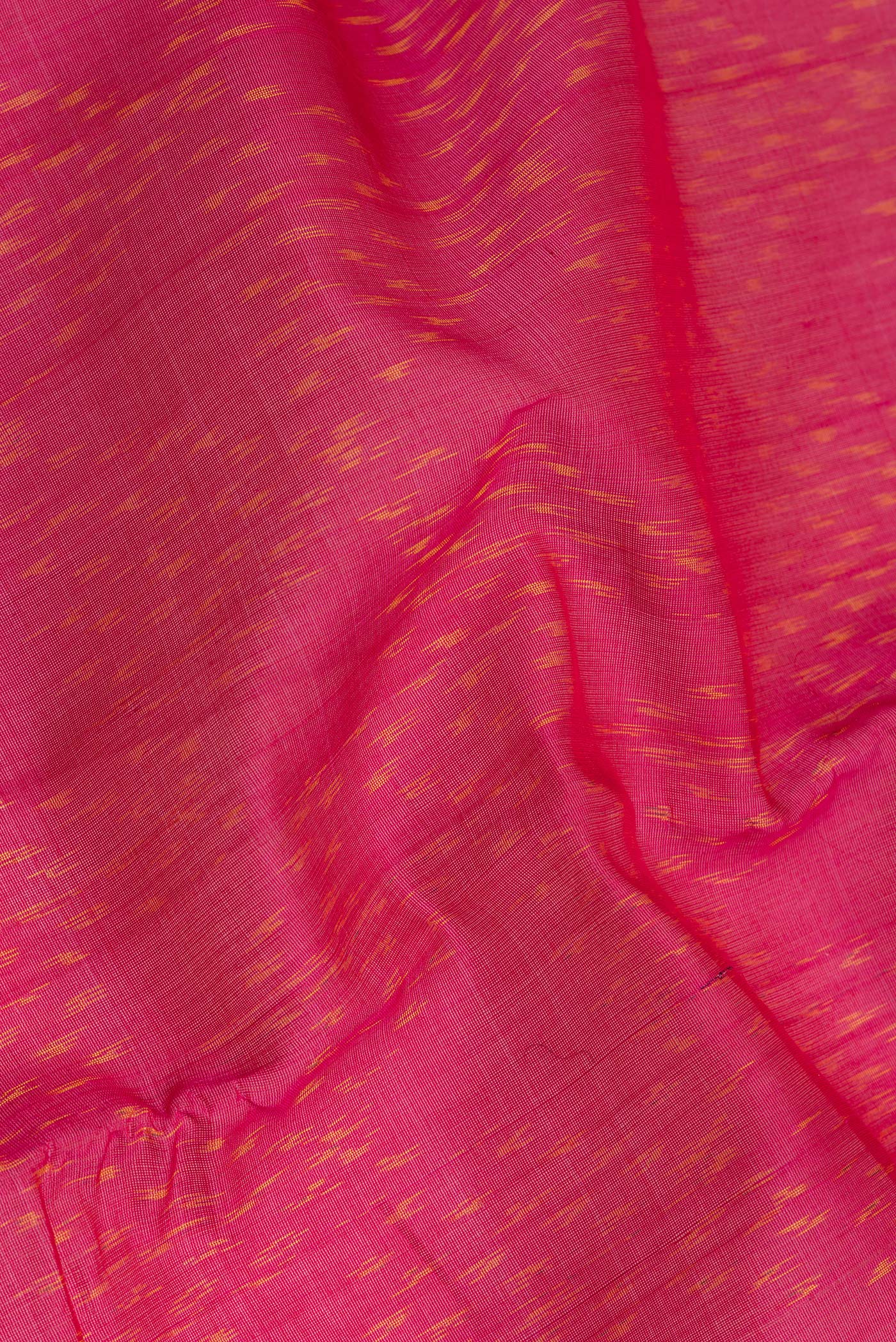 Close up of Dark Pink Silk Cotton Saree with Ikat Print on the body and Zari Border.  displaying folds