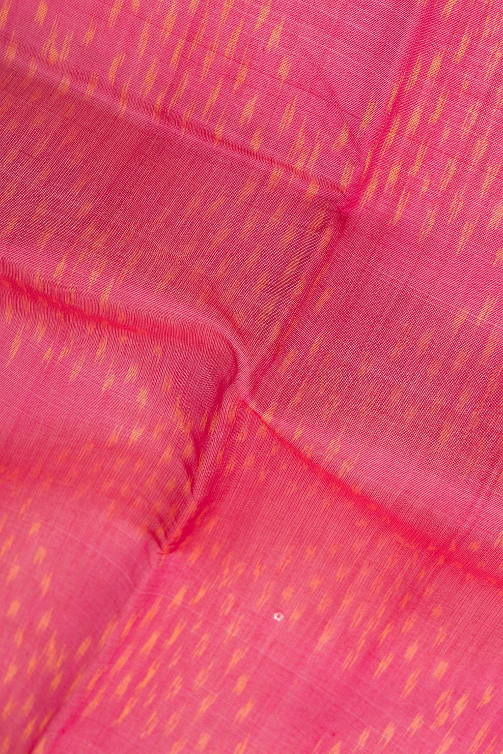 Close up of Dark Pink Silk Cotton Saree with Ikat Print on the body and Zari Border.  displaying folds