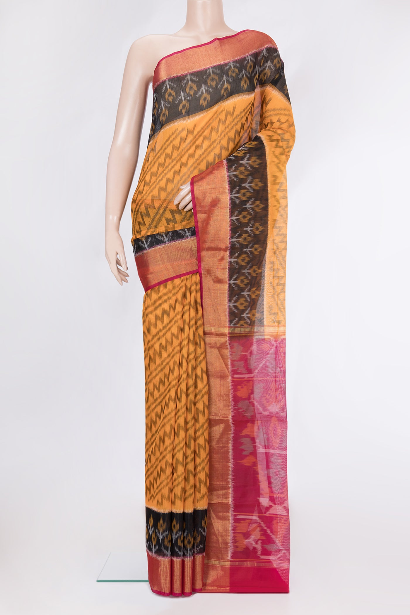 Mustard Silk Cotton Saree with Ikat Print on the body and Ikat Border.  displayed on a mannequin