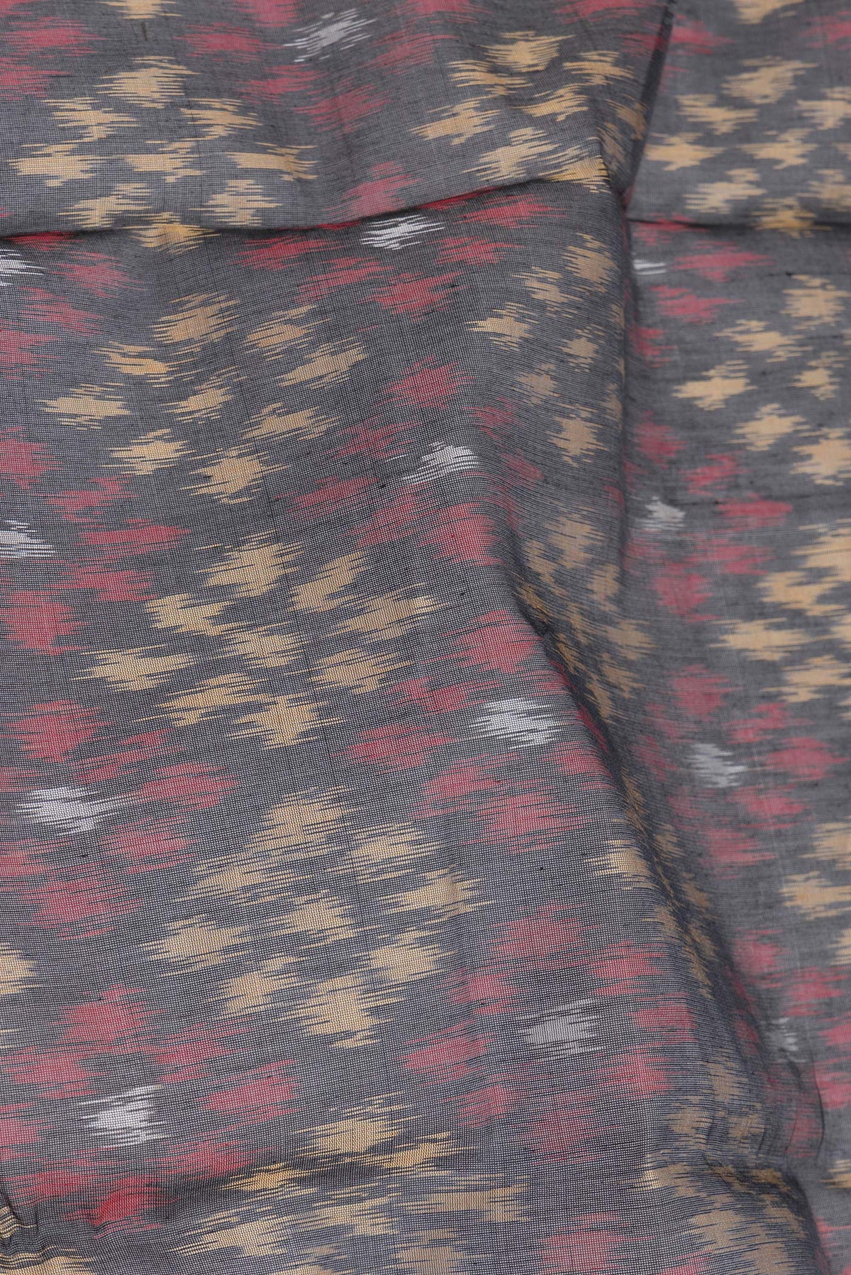 Close up of Black Silk Cotton Saree with Ikat Print on the body and Zari Border.  displaying folds
