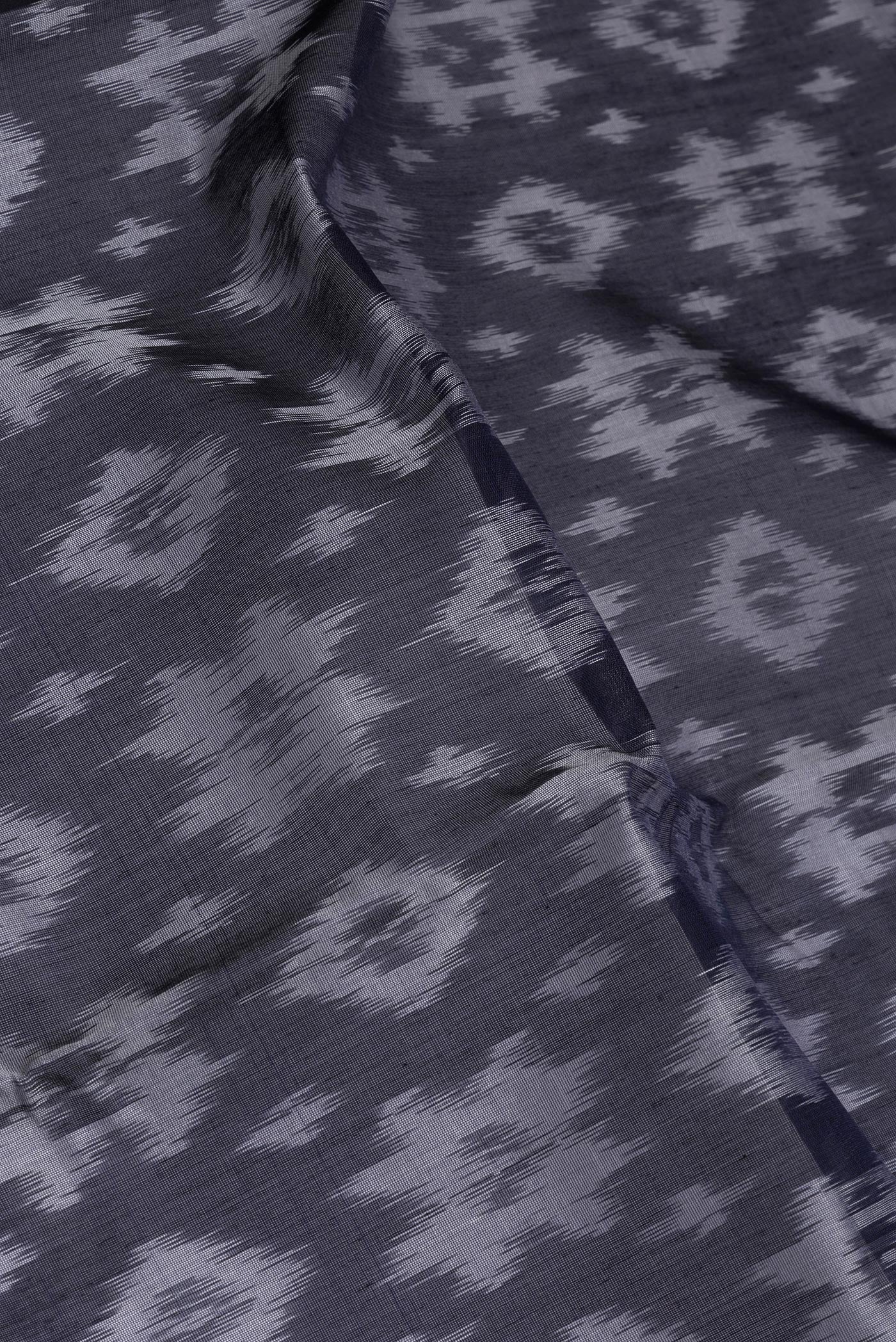 Close up of Black Silk Cotton Saree with Ikat Print on the body and Zari Border.  displaying folds