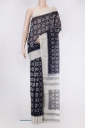 Black Silk Cotton Saree with Ikat Print on the body and Zari Border.  displayed on a mannequin