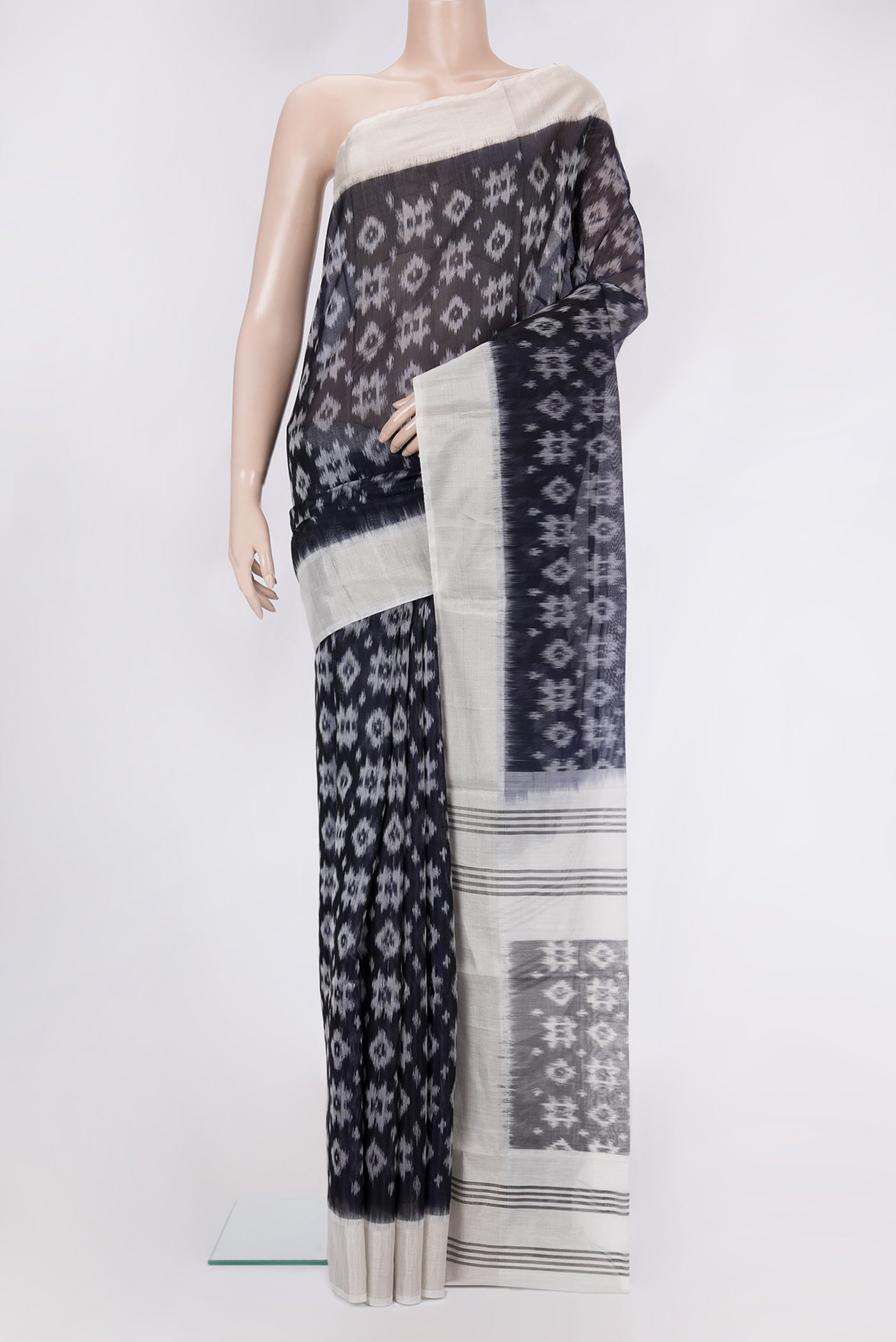 Black Silk Cotton Saree with Ikat Print on the body and Zari Border.  displayed on a mannequin