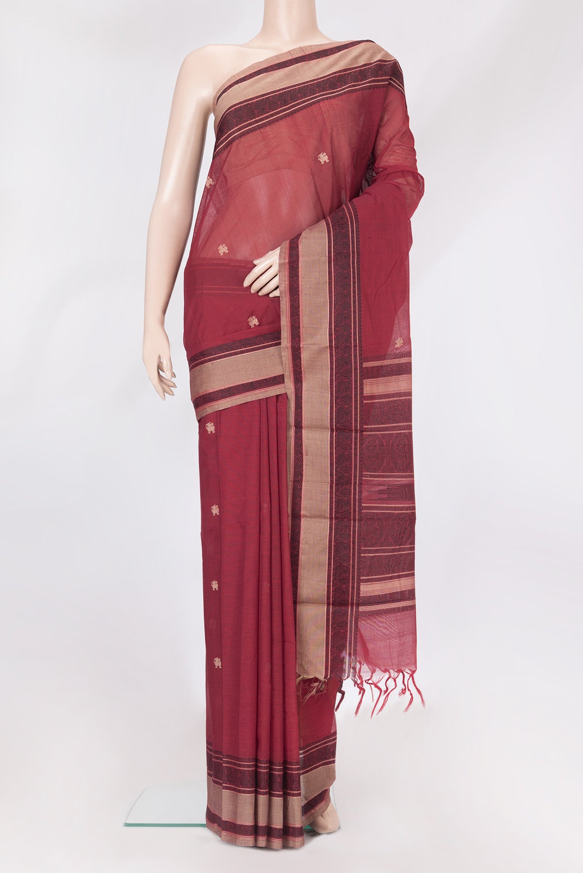 Maroon Kanchi Cotton Saree with Thread Butta on the body and Thread Border.  displayed on a mannequin
