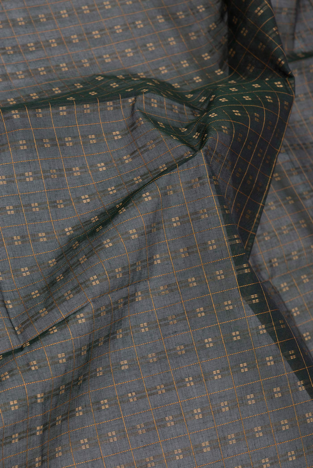 Close up of Bottle Green Kanchi Cotton Saree with Checked design on the body and Thread Border.  displaying folds