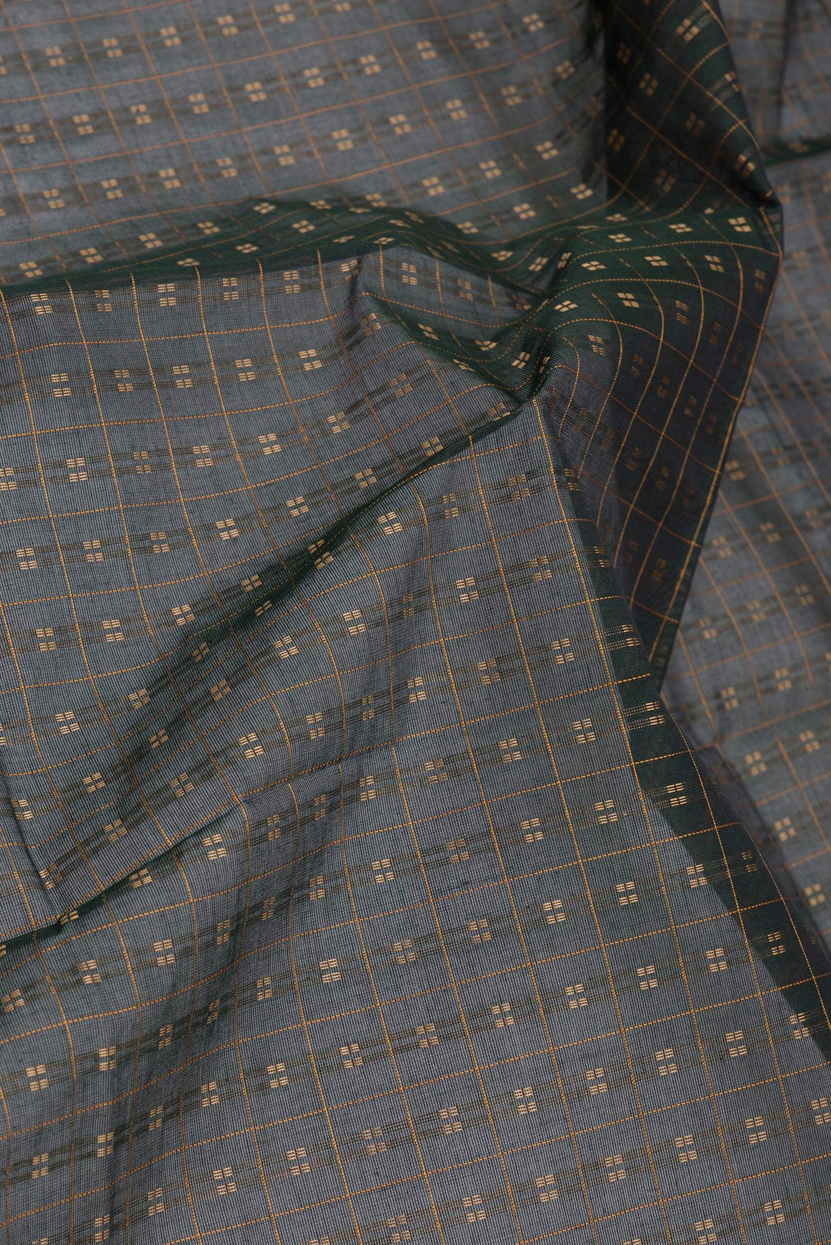 Close up of Bottle Green Kanchi Cotton Saree with Checked design on the body and Thread Border.  displaying folds