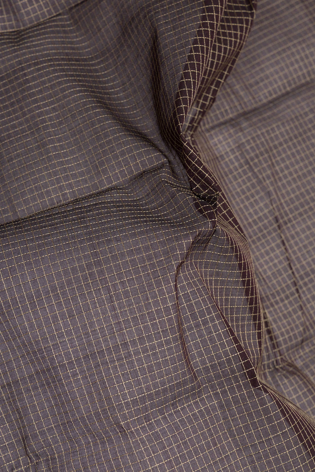 Close up of Brown Kanchi Cotton Saree with Checked design on the body and Thread Border.  displaying folds
