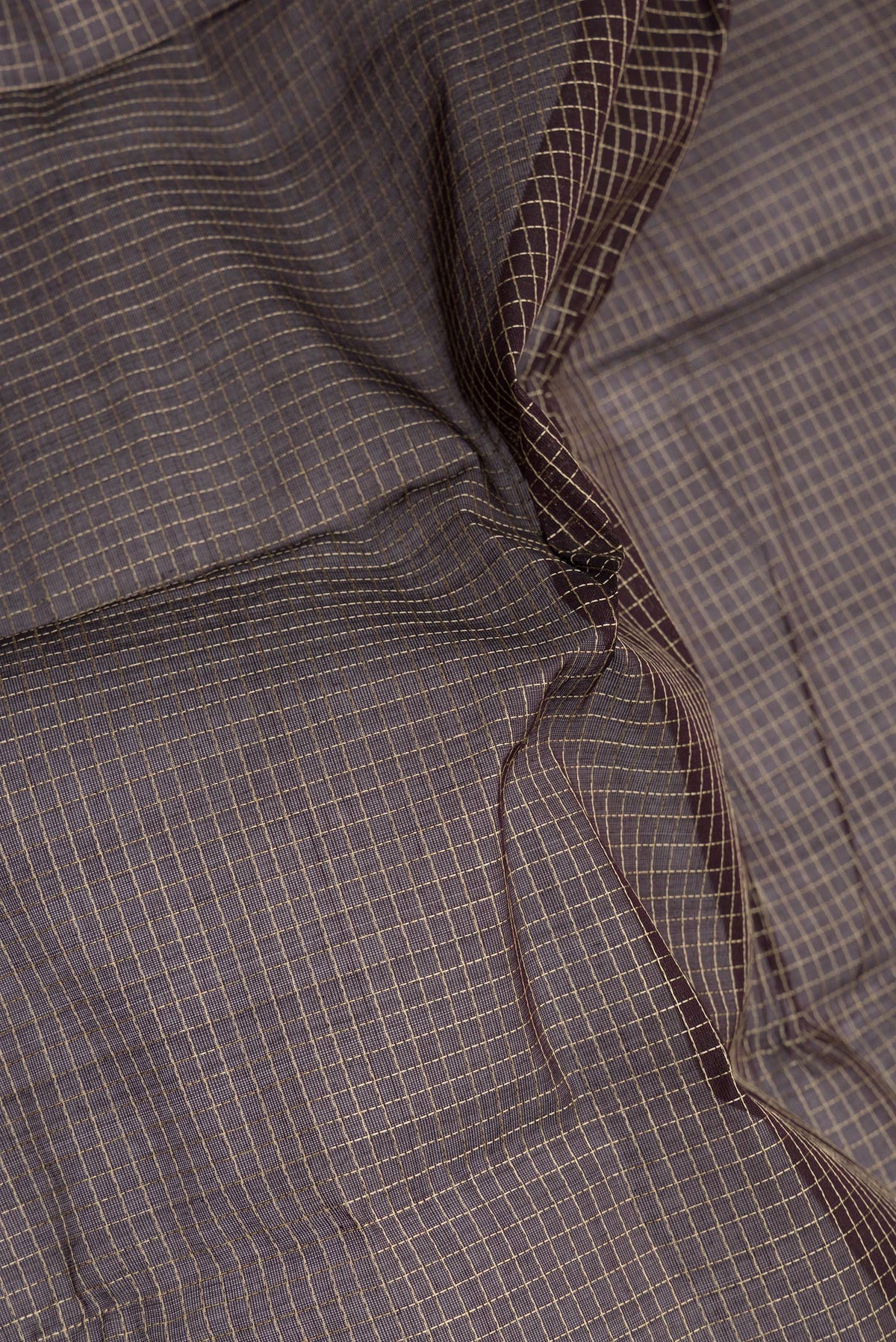 Close up of Brown Kanchi Cotton Saree with Checked design on the body and Thread Border.  displaying folds