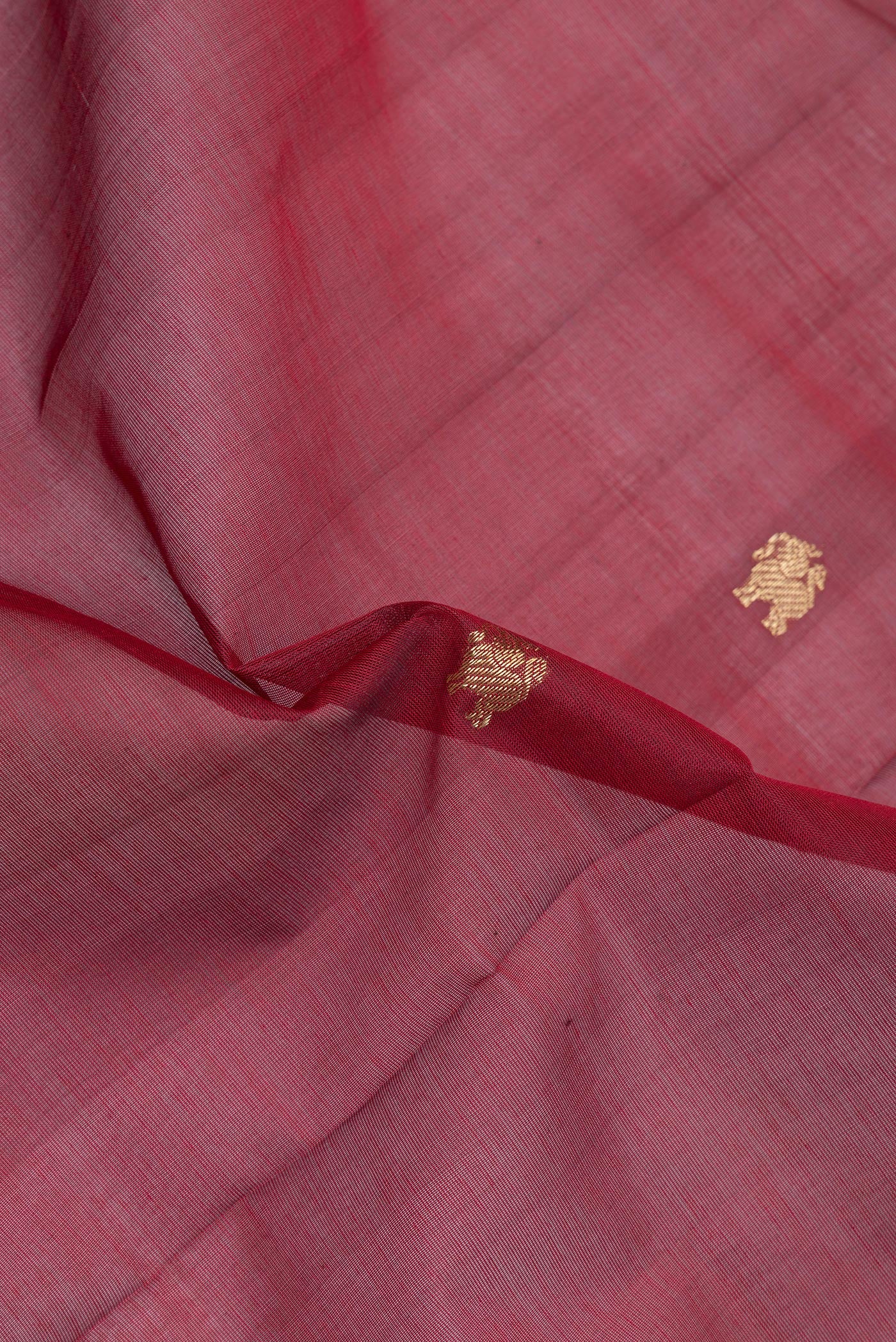 Close up of Maroon Silk Cotton Saree with Zari Butta on the body and Zari Border.  displaying folds