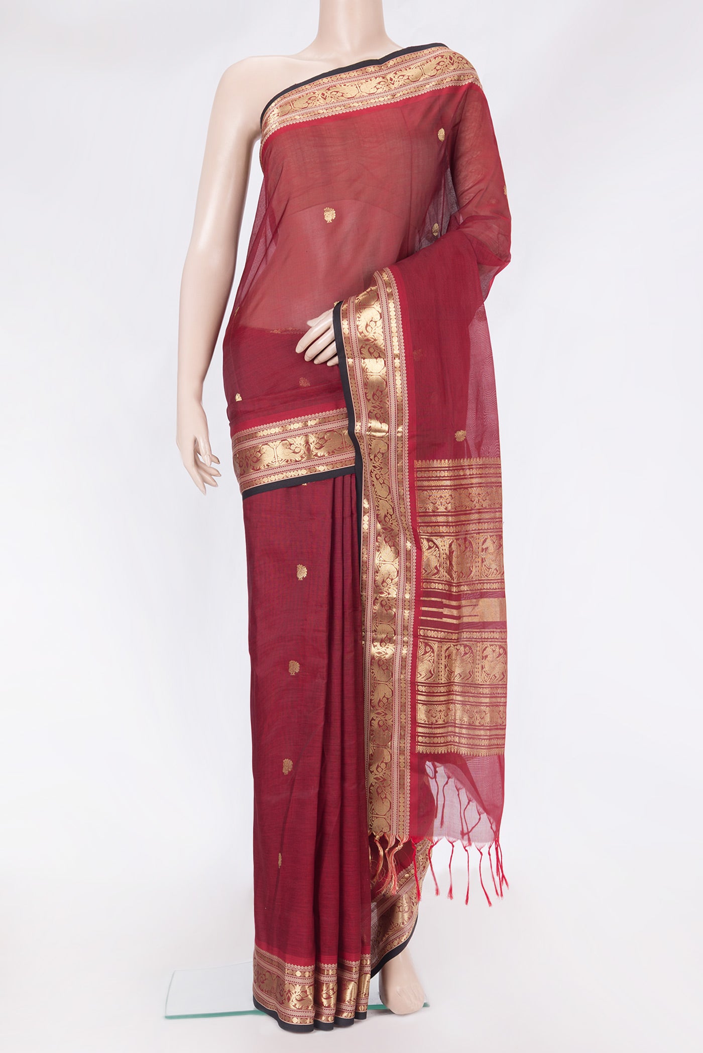 Maroon Silk Cotton Saree with Zari Butta on the body and Zari Border.  displayed on a mannequin