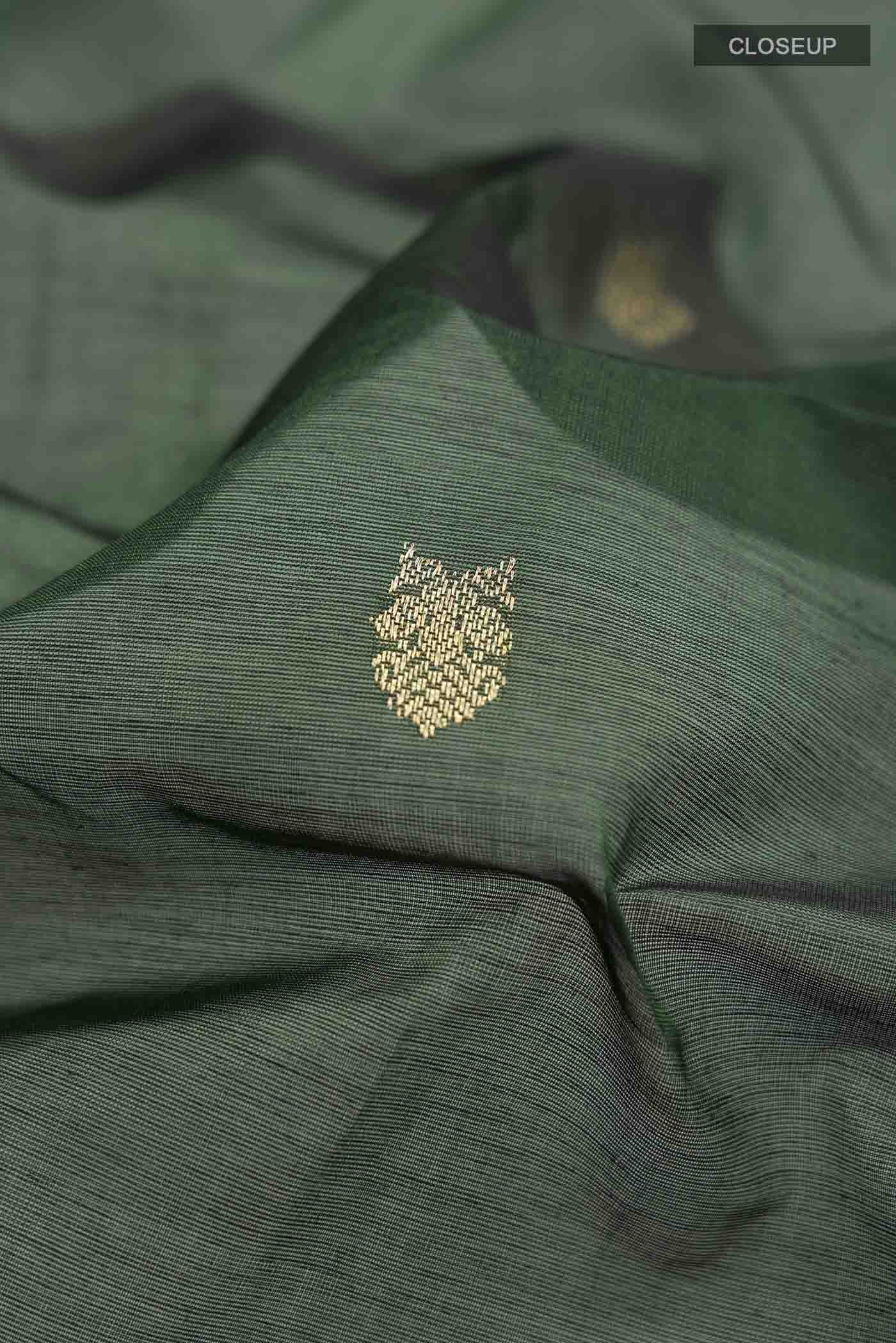 Close up of Green Silk Cotton Saree with Zari Butta on the body and Zari Border displaying folds