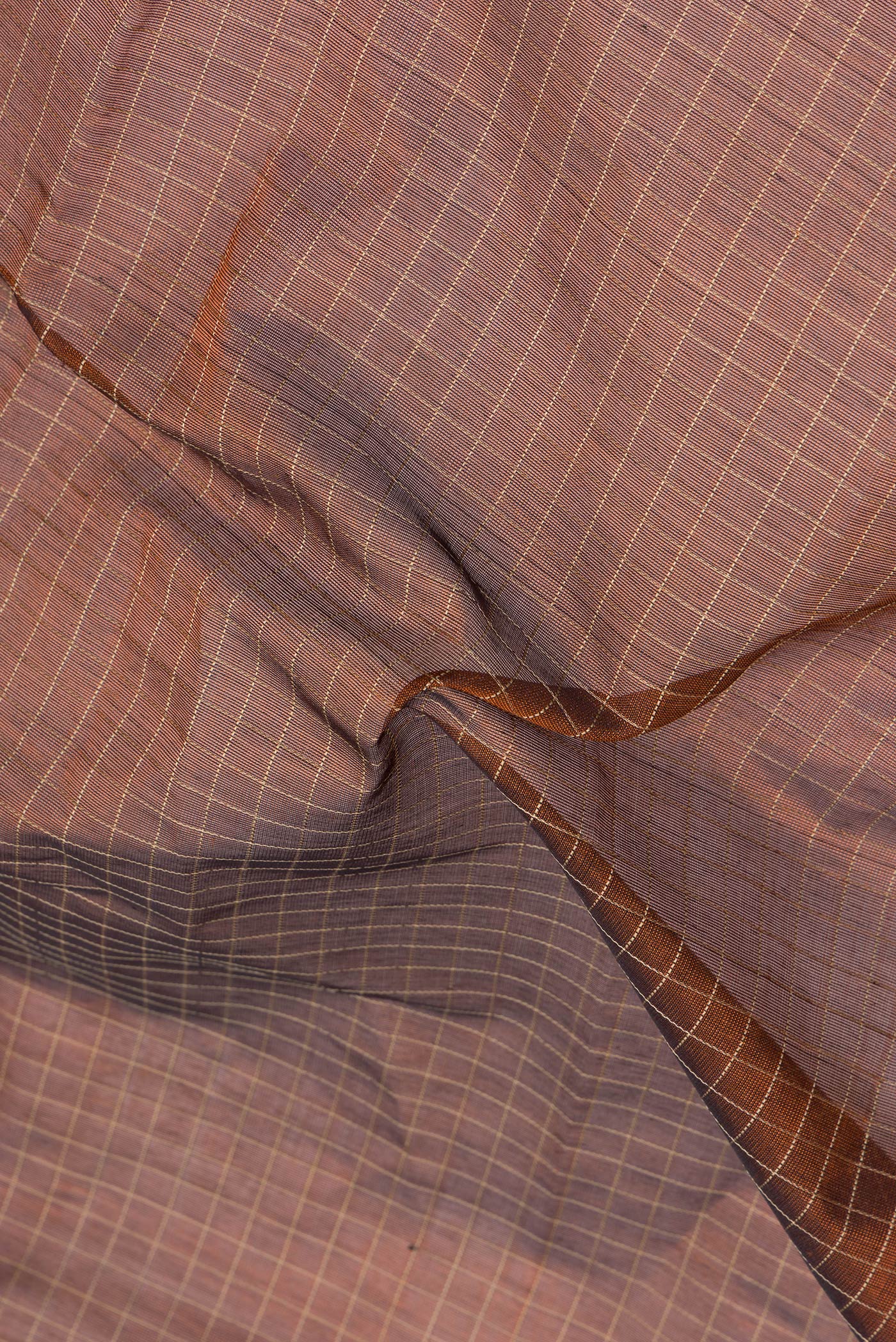 Close up of Brown Silk Cotton Saree with Checked design on the body and Zari Border.  displaying folds