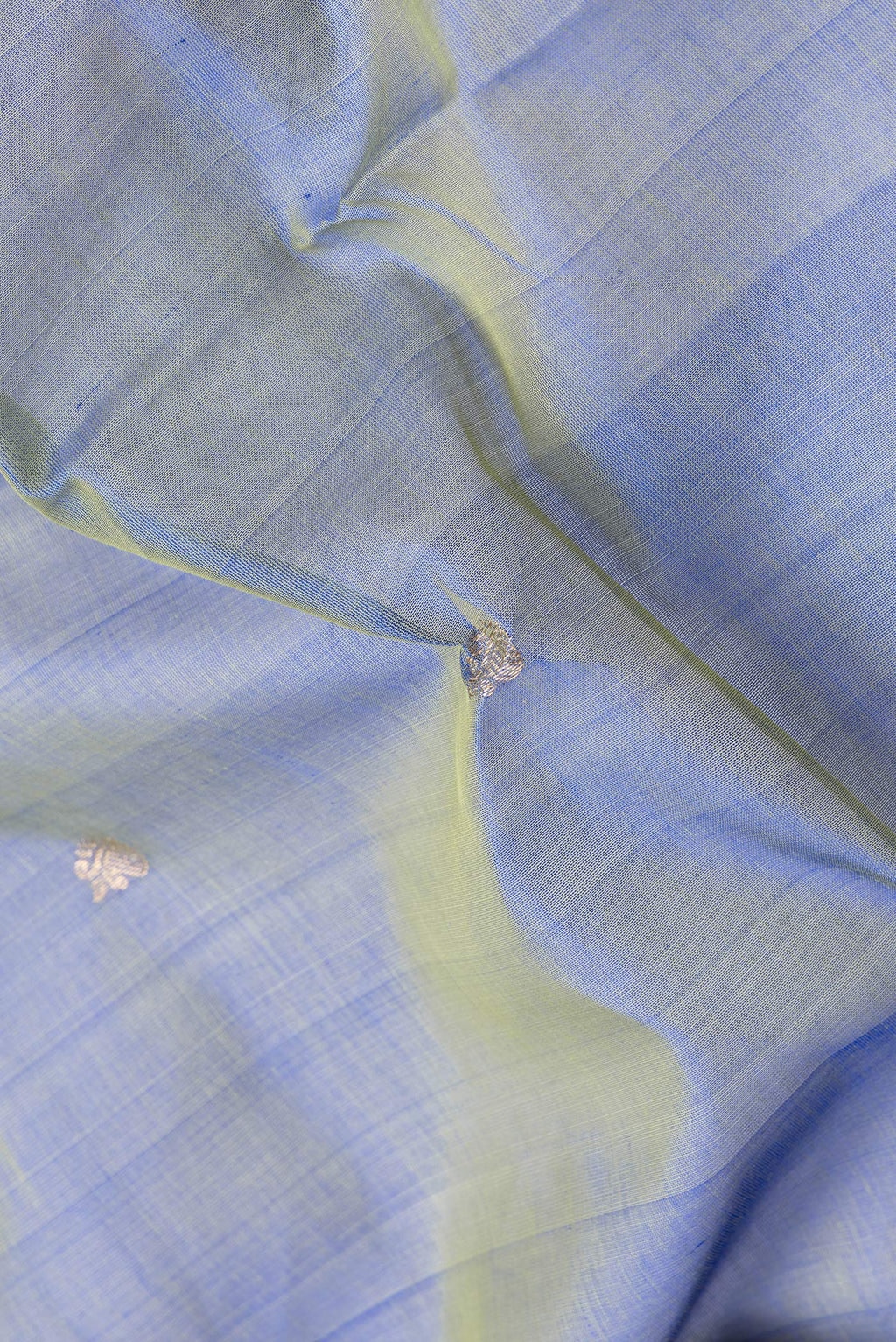 Close up of Peacock Blue Dual Tone Silk Cotton Saree with Zari Butta on the body and Zari And Thread Border.  displaying folds