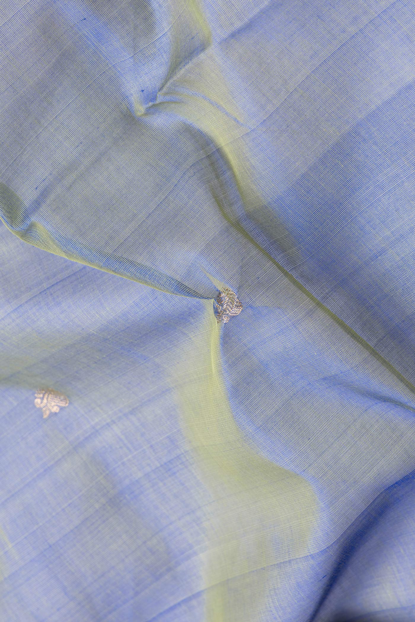 Close up of Peacock Blue Dual Tone Silk Cotton Saree with Zari Butta on the body and Zari And Thread Border.  displaying folds