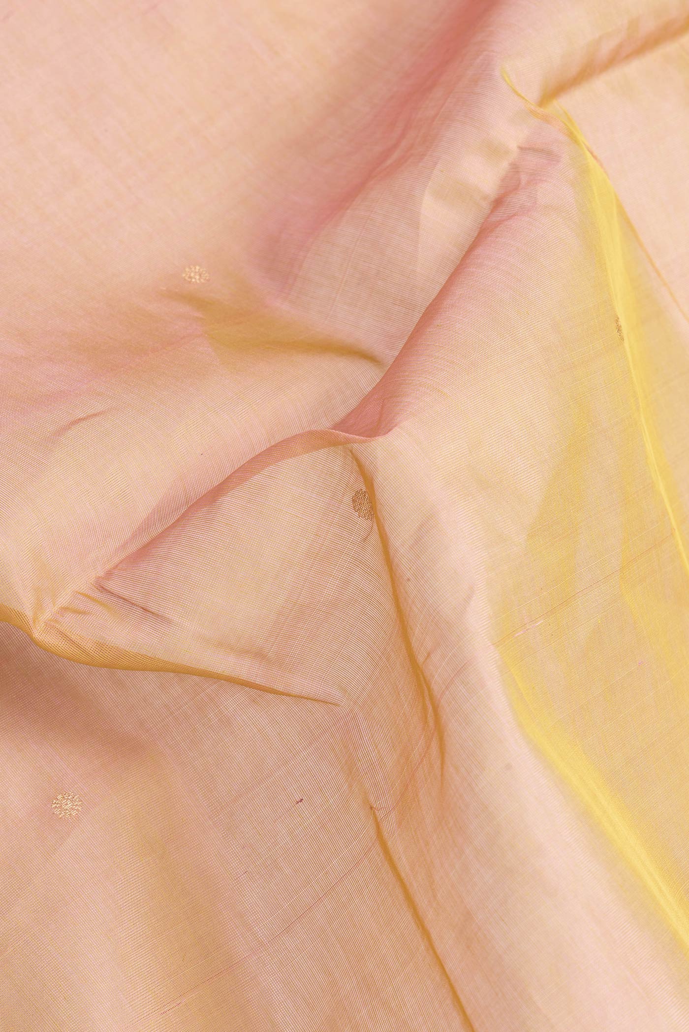 Close up of Rose Gold Dual Tone Silk Cotton Saree with Zari Butta on the body and Zari Border.  displaying folds
