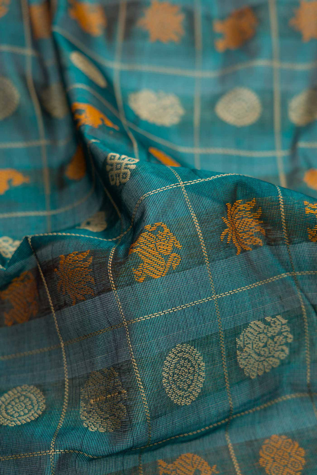 Close up of Peacock Blue Dual Tone Silk Cotton Saree with Checked design on the body and Zari Border.  displaying folds