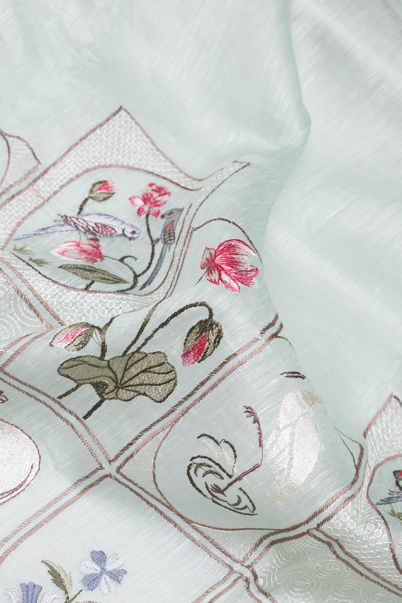 Close up of Mint Green Linen Saree with Embroidery on the body and Zari Border.  displaying folds