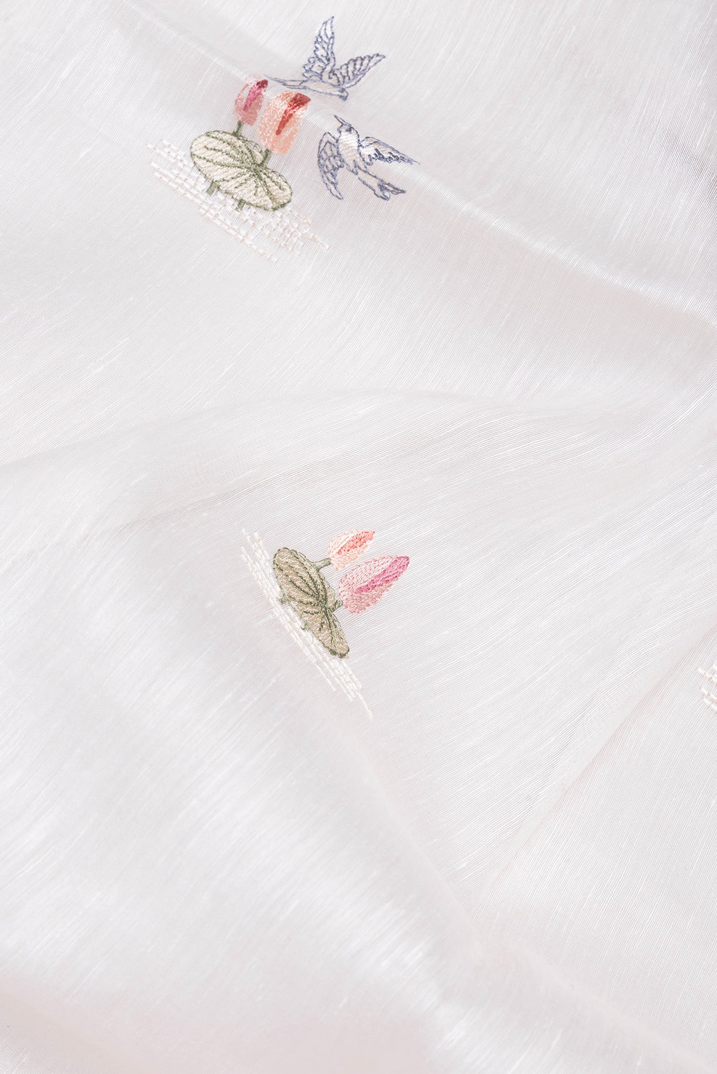 Close up of Off White Linen Saree with Embroidery on the body and Zari Border.  displaying folds