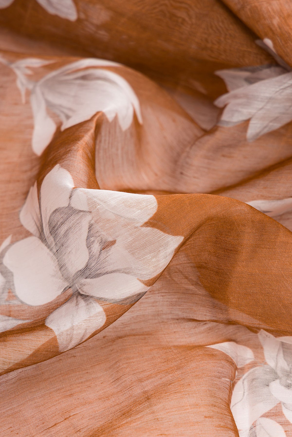 Close up of Brown Linen Saree with Floral Print on the body and Plain Border.  displaying folds