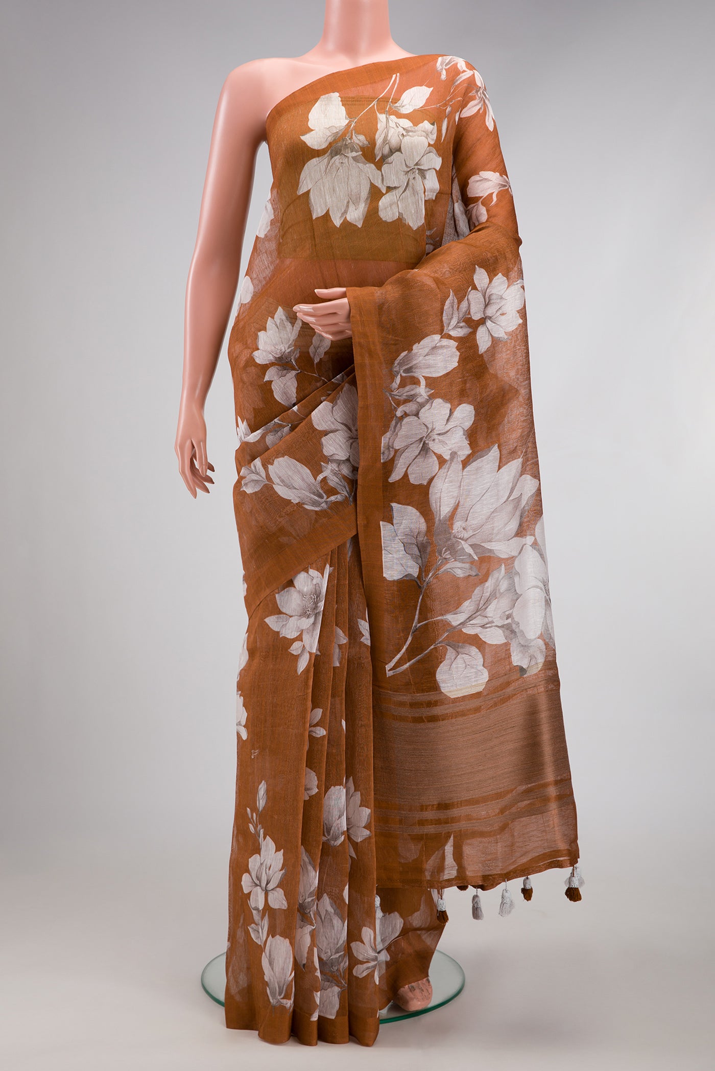 Brown Linen Saree with Floral Print on the body and Plain Border.  displayed on a mannequin