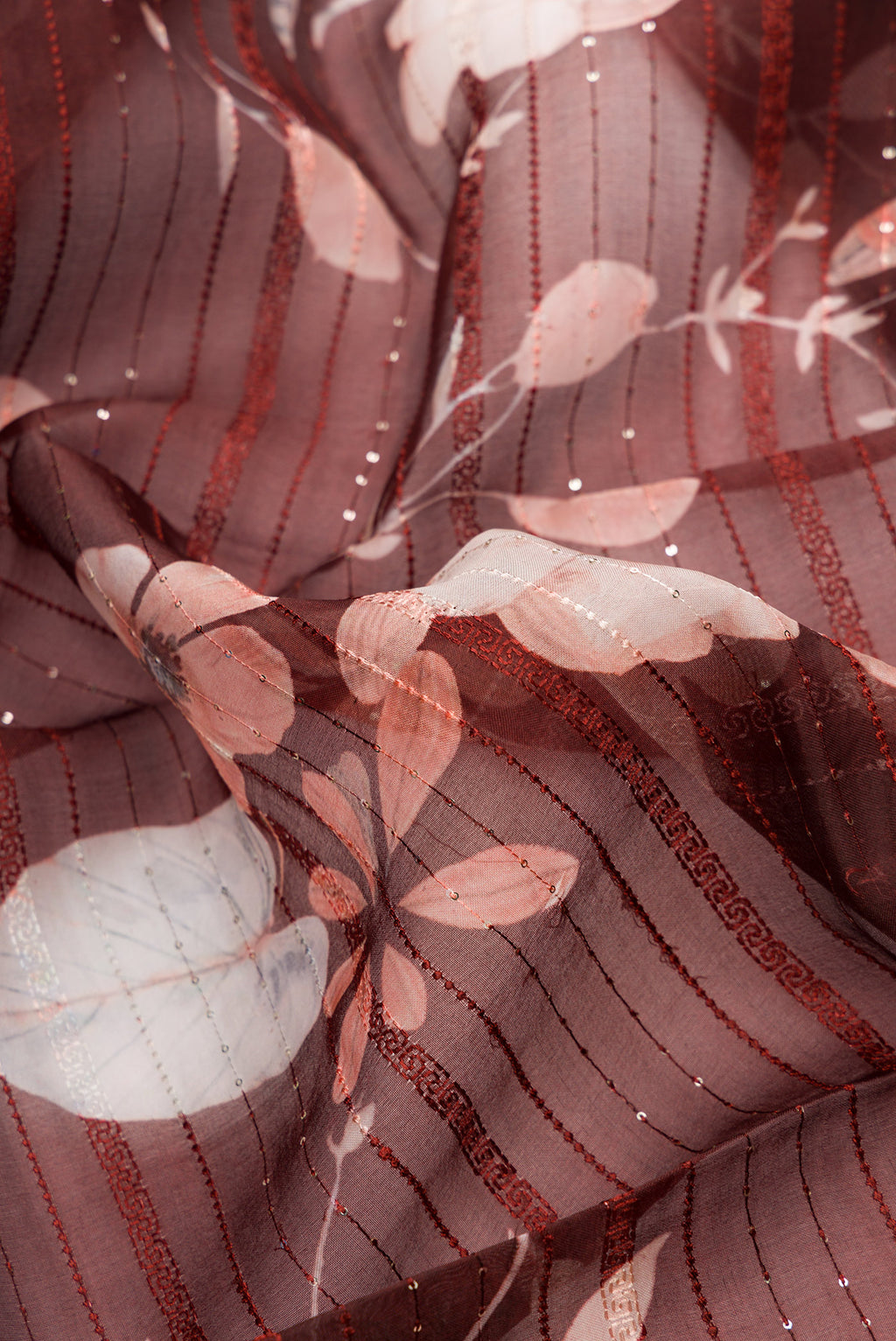 Close up of Maroon Dual Tone Organza Silk Saree with Printed design on the body and Embroidery Border.  displaying folds