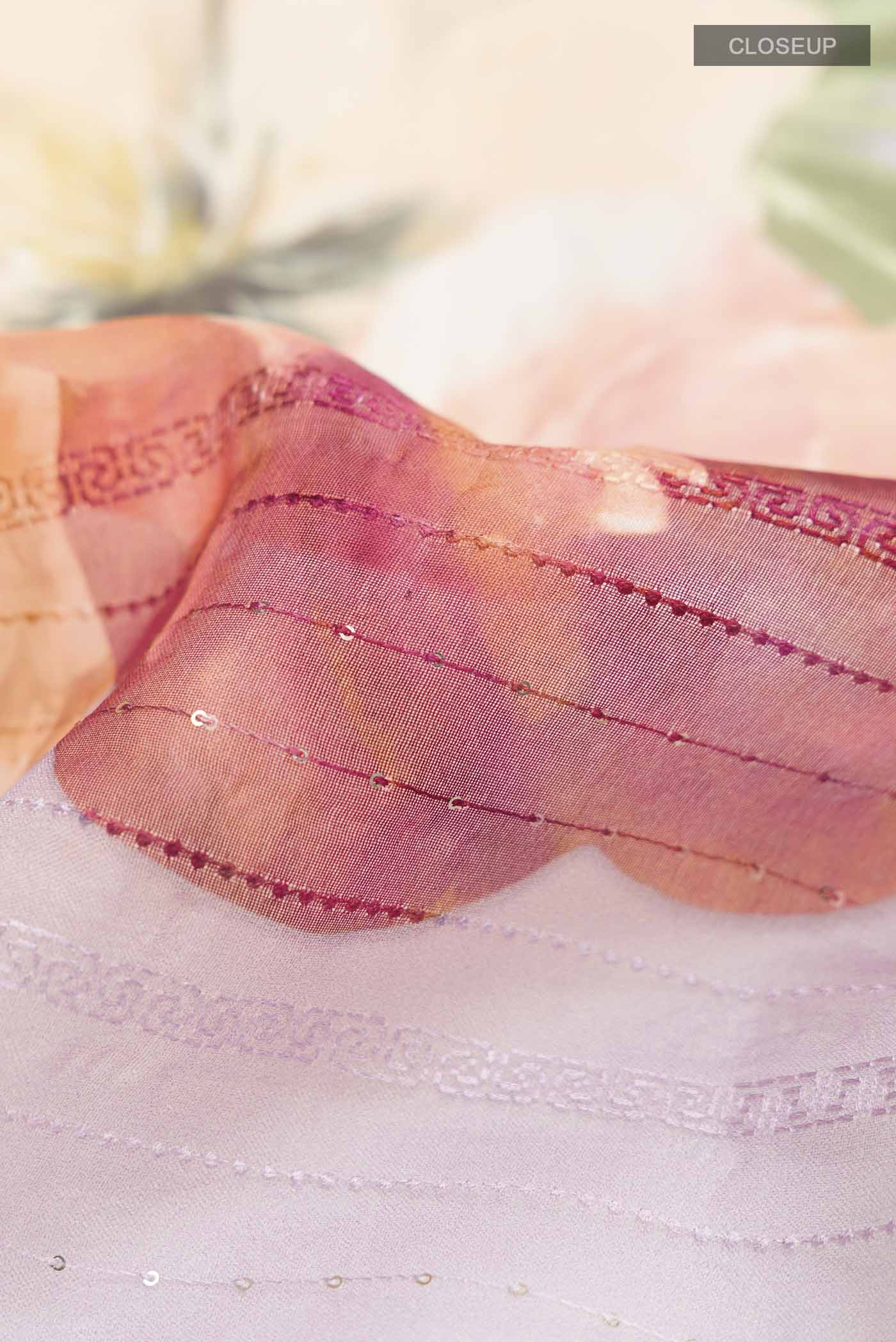 Close up of Lavender Organza Silk Saree with Printed design on the body and Embroidery Border displaying folds