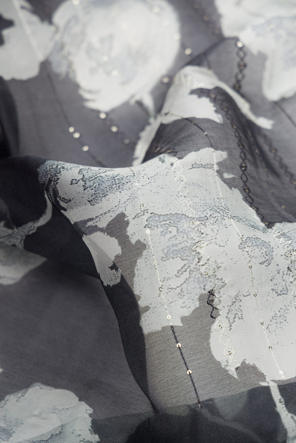 Close up of Black Dual Tone Organza Silk Saree with Printed design on the body and Printed Border.  displaying folds