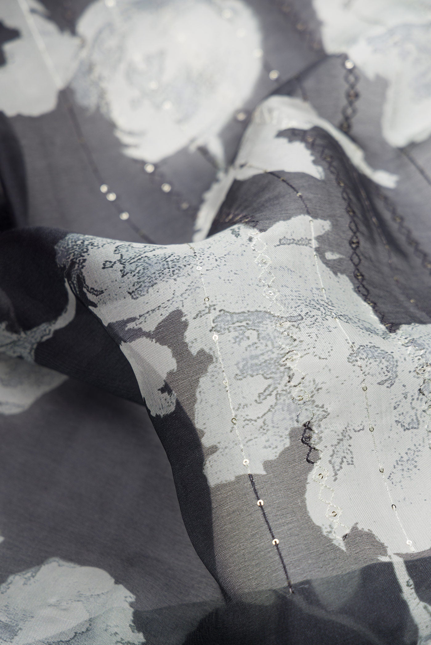 Close up of Black Dual Tone Organza Silk Saree with Printed design on the body and Printed Border.  displaying folds