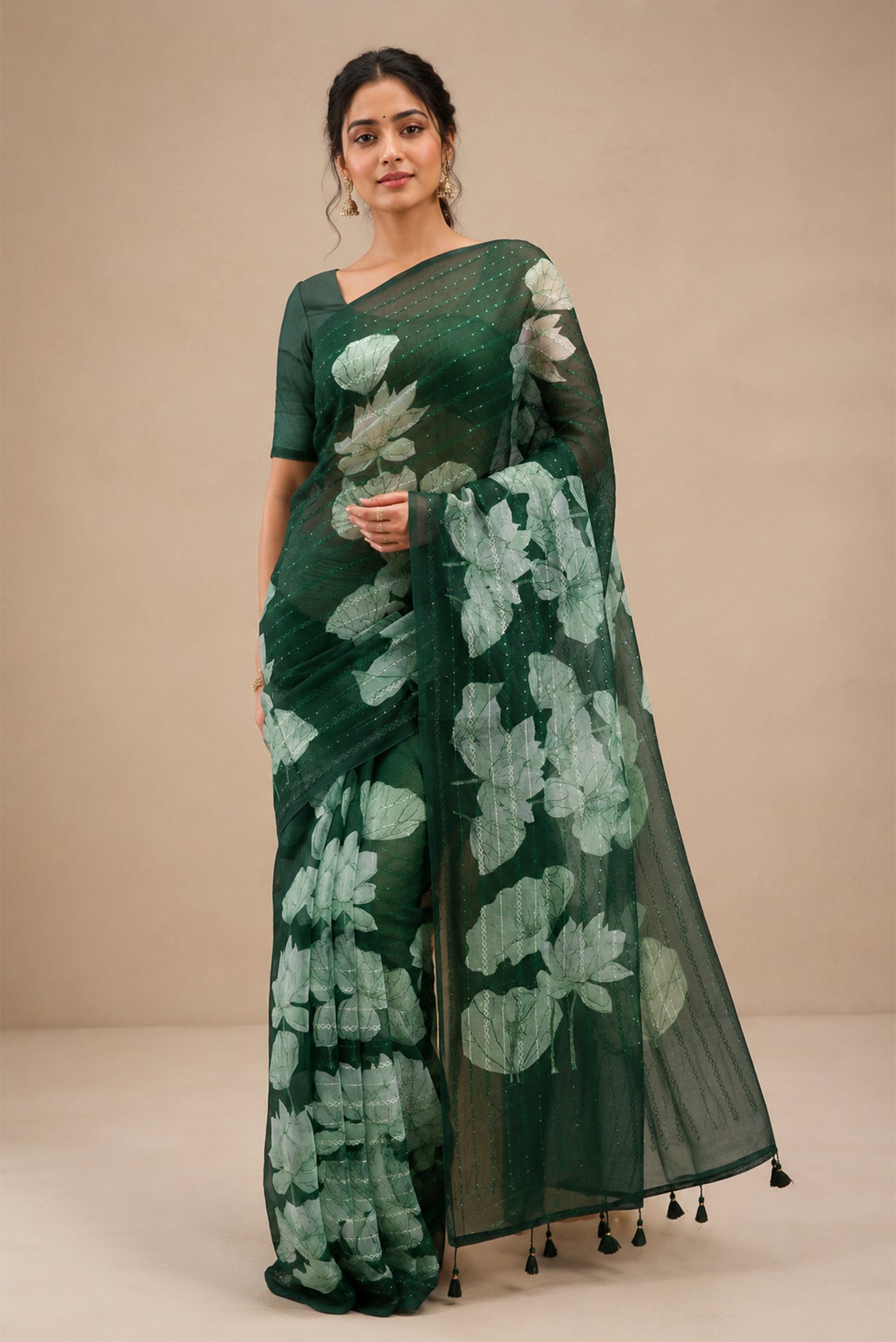 Model wearing a Bottle Green Organza Silk Saree with Embroidery on the body and Without Border.