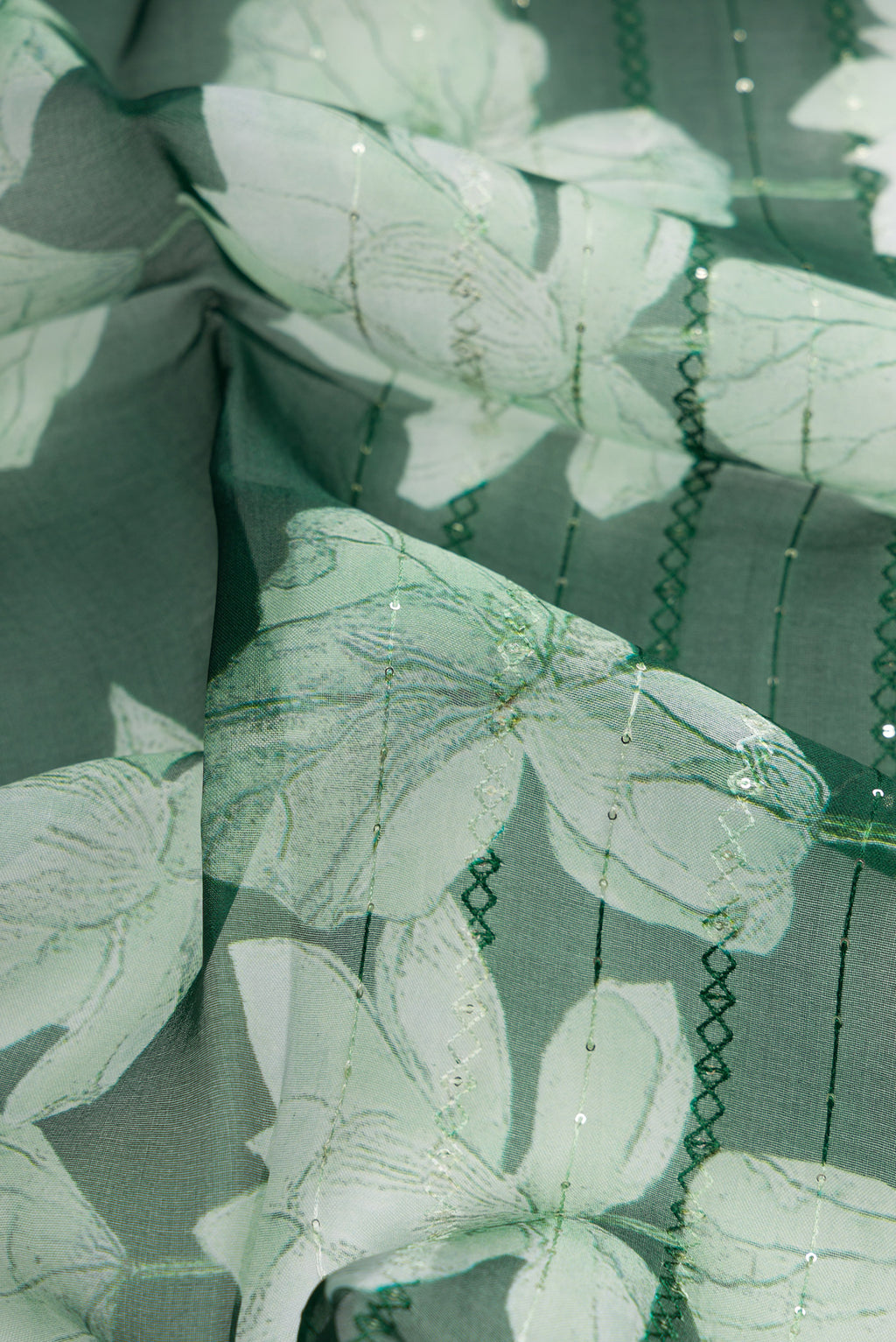 Close up of Bottle Green Dual Tone Organza Silk Saree with Embroidery on the body and Without Border.  displaying folds