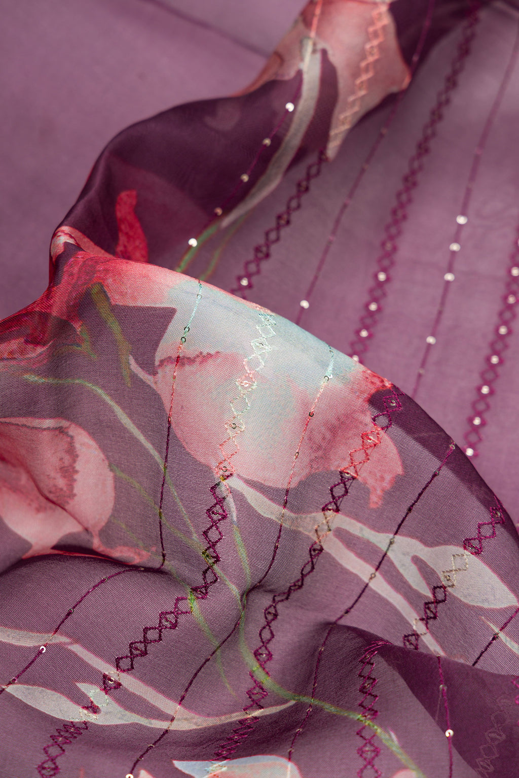 Close up of Burgundy Dual Tone Organza Silk Saree with Printed design on the body and Without Border.  displaying folds