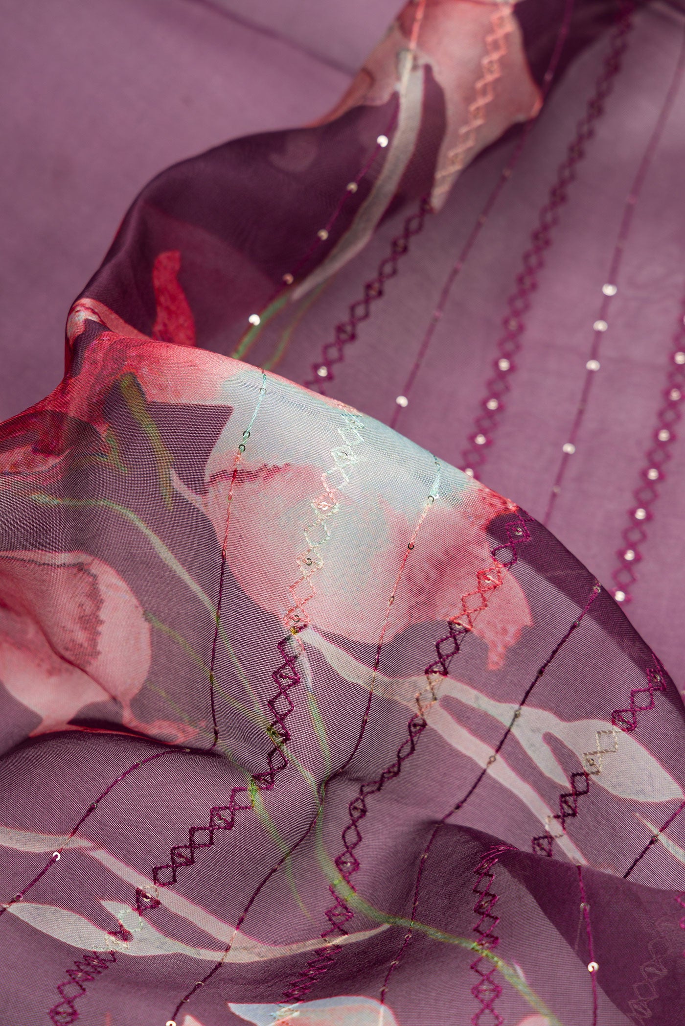 Close up of Burgundy Dual Tone Organza Silk Saree with Printed design on the body and Without Border.  displaying folds