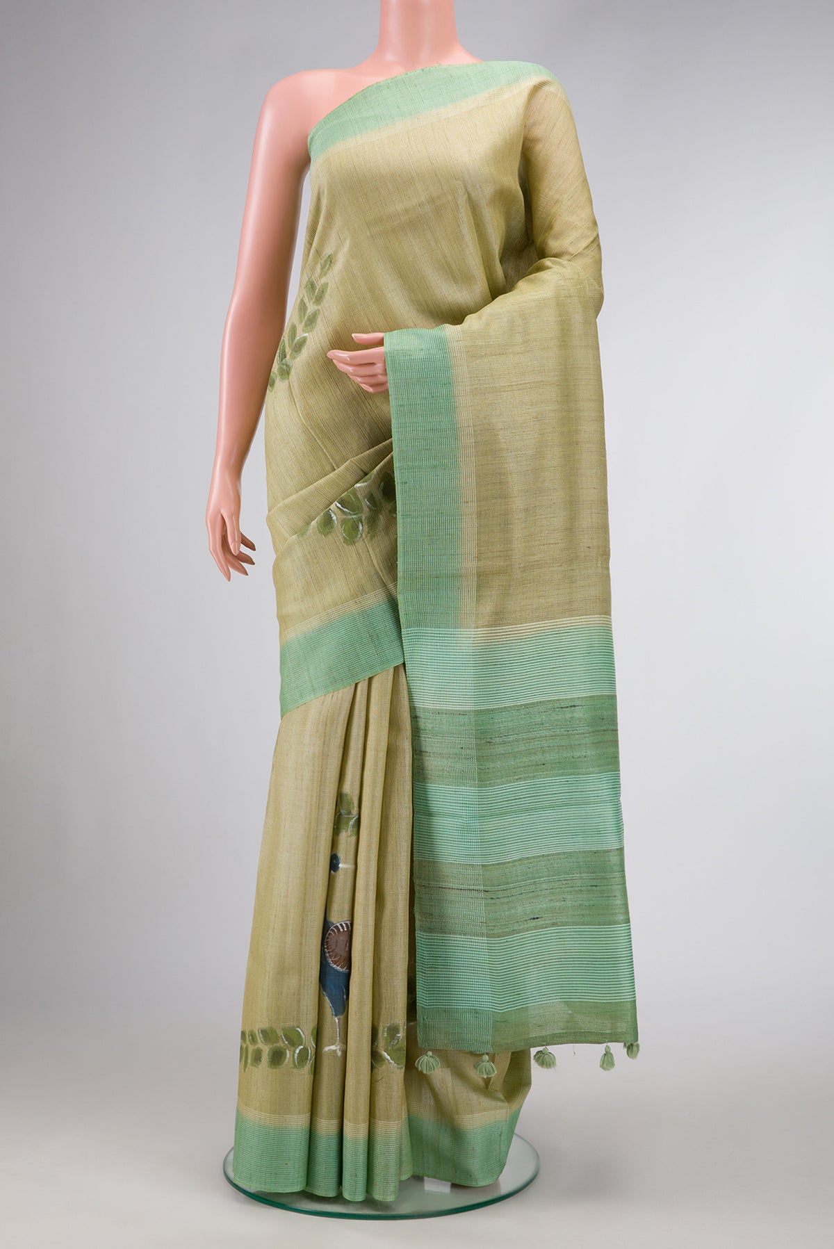 Pista Green Dual Tone Tussar Silk Saree with Printed design on the body and Plain Border.  displayed on a mannequin