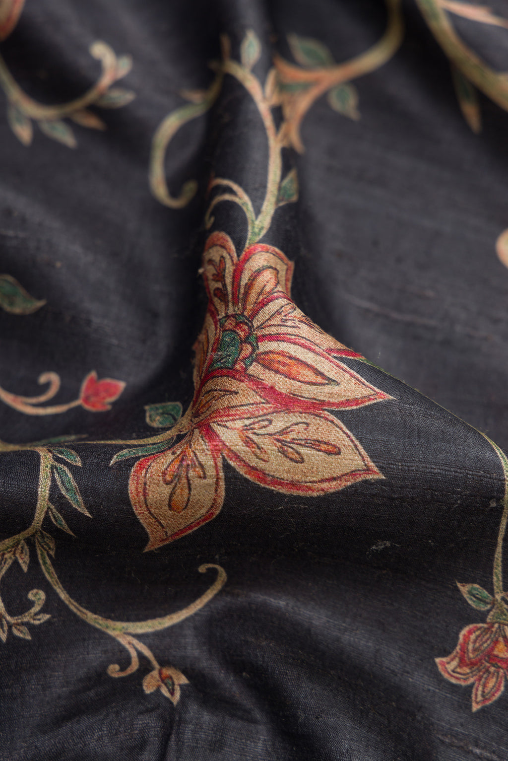 Close up of Black Dual Tone Tussar Silk Saree with Printed design on the body and Embroidery Border.  displaying folds