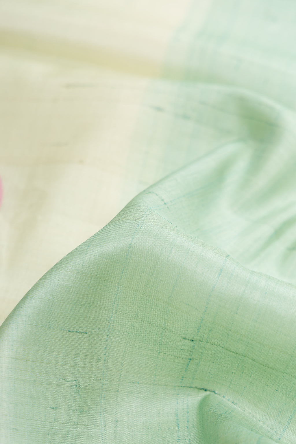 Close up of Pista Green Dual Tone Tussar Silk Saree with Plain Body and Fancy Border.  displaying folds