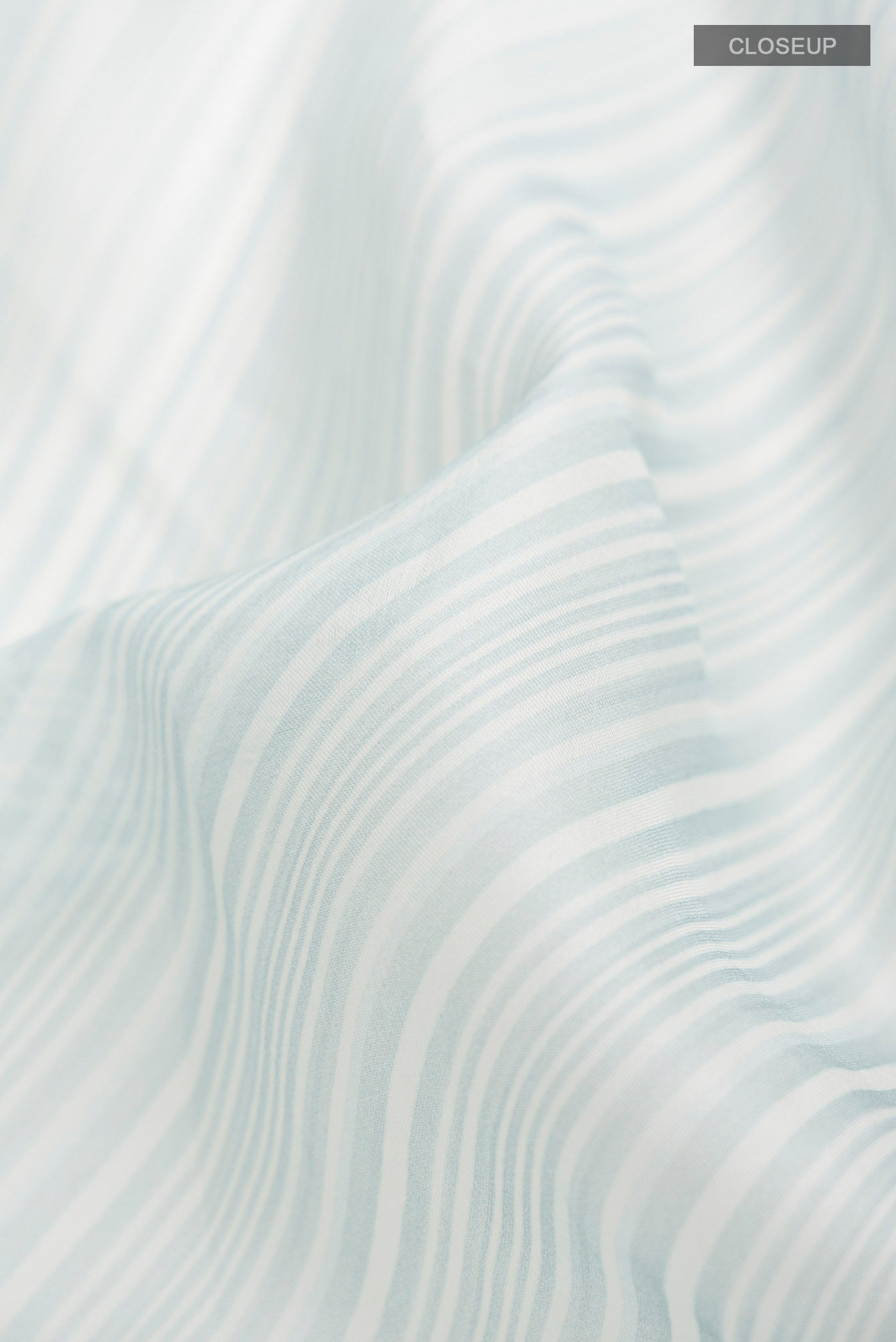 Close up of Light Blue Organza Silk Saree with Printed design on the body and Printed Border displaying folds