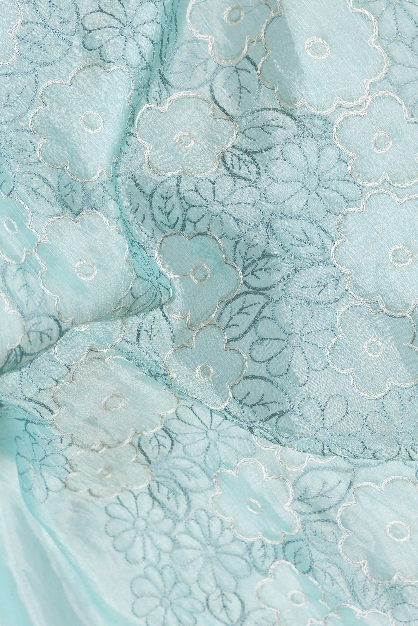 Close up of Sea Green Dual Tone Organza Silk Saree with Embroidery on the body and Embroidery Border.  displaying folds