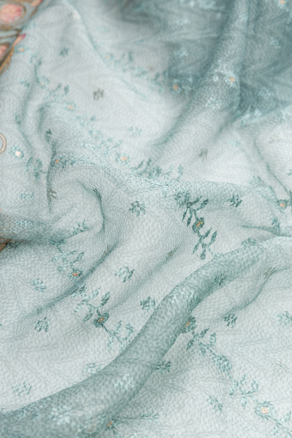 Close up of Maya Blue Dual Tone Organza Silk Saree with Embroidery on the body and Embroidery Border.  displaying folds