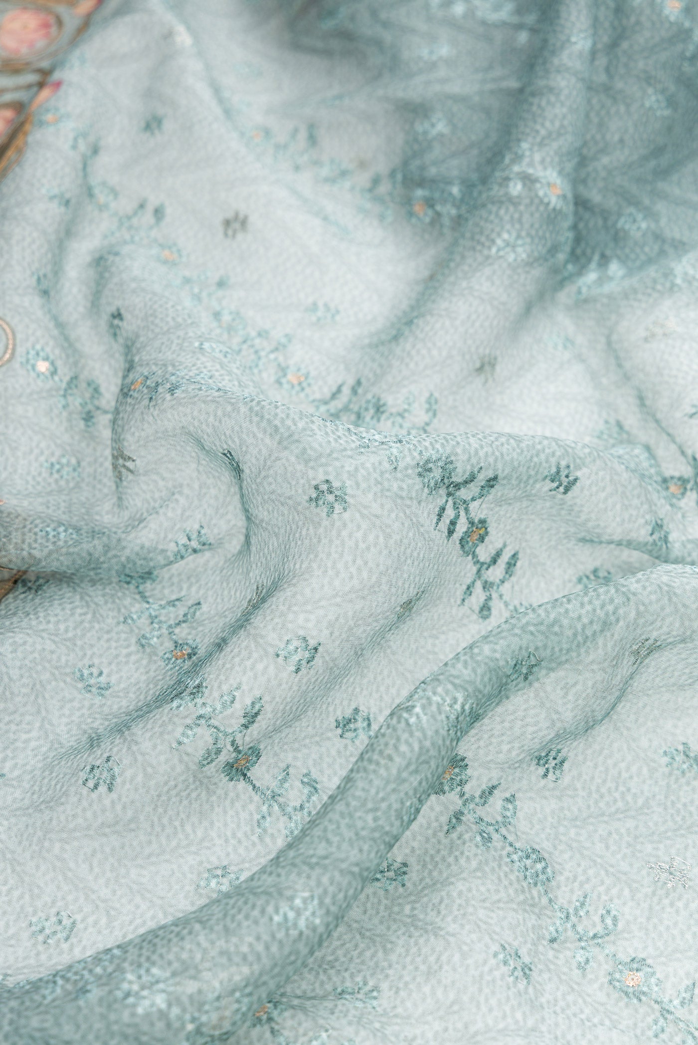 Close up of Maya Blue Dual Tone Organza Silk Saree with Embroidery on the body and Embroidery Border.  displaying folds