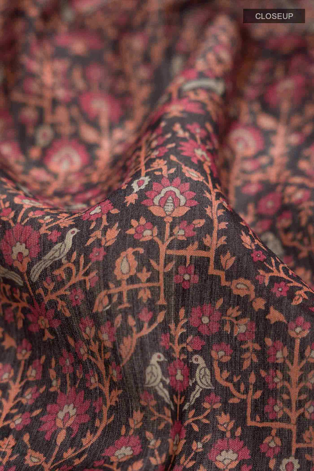 Close up of Black Tussar Silk Saree with Printed design on the body and Zari Border displaying folds