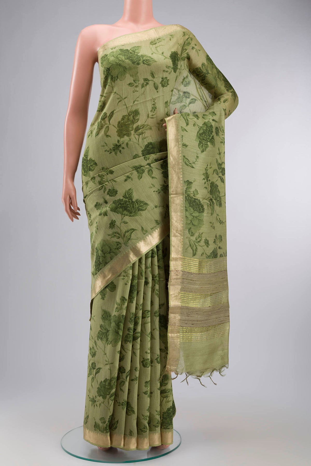 Green Tussar Silk Saree with Printed design on the body and Zari Border displayed on a mannequin