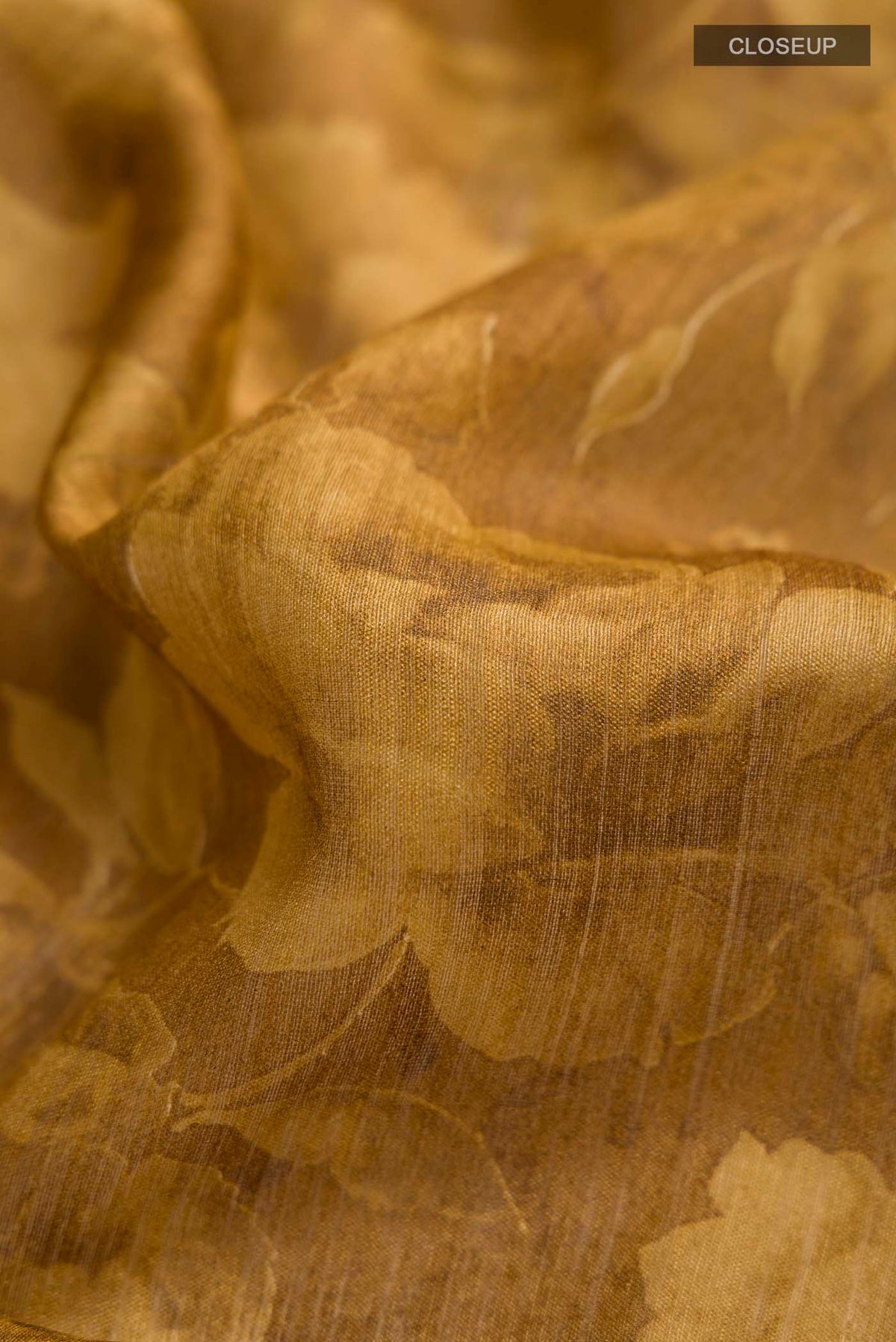 Close up of Mustard Bhagalpuri Tussar Silk Saree with Printed design on the body and Zari Border displaying folds