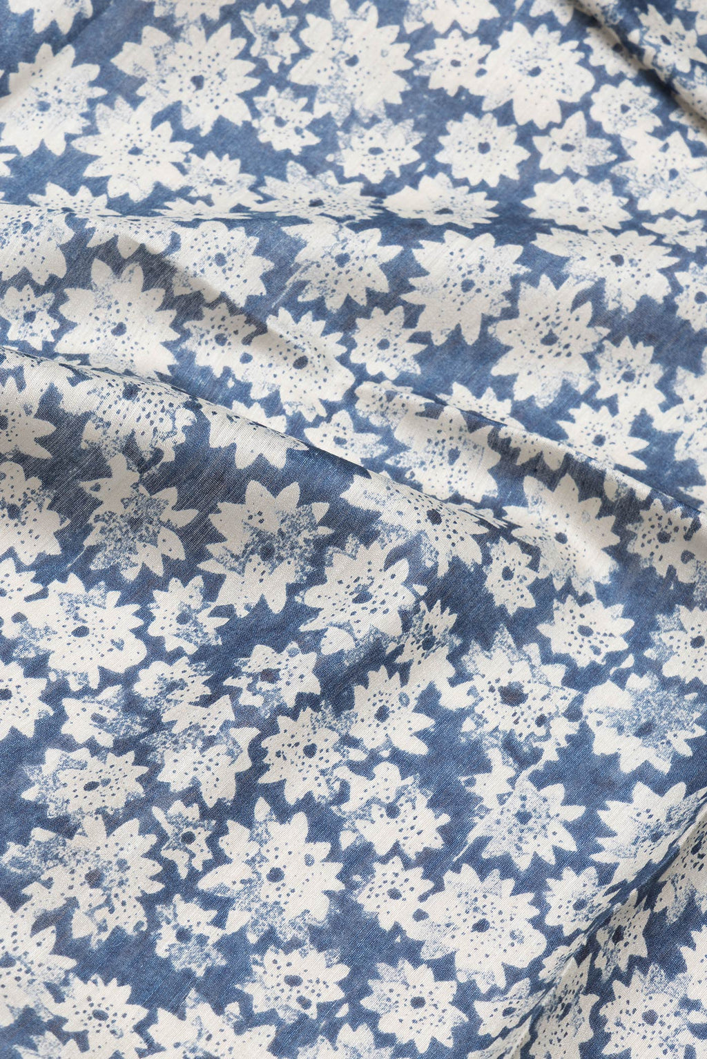 Close up of Blue Dual Tone Tussar Silk Saree with Printed design on the body and Zari Border.  displaying folds