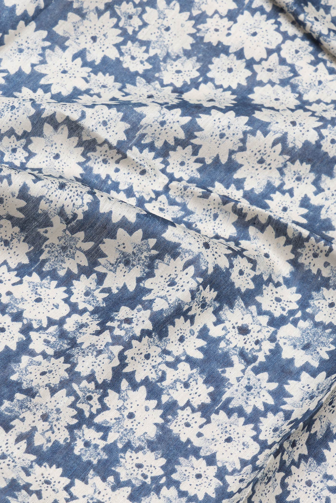 Close up of Blue Dual Tone Tussar Silk Saree with Printed design on the body and Zari Border.  displaying folds